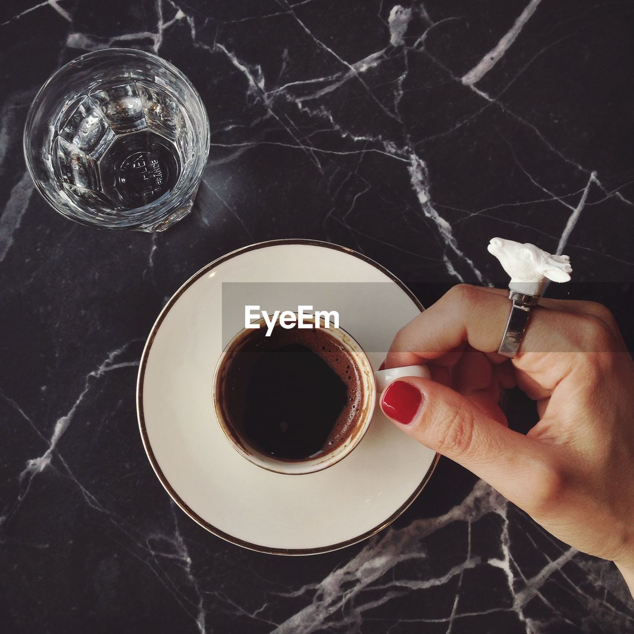 Cropped image of woman hand holding coffee cup on table