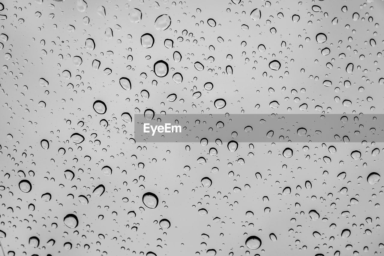 FULL FRAME SHOT OF WATER DROPS ON GLASS WINDOW