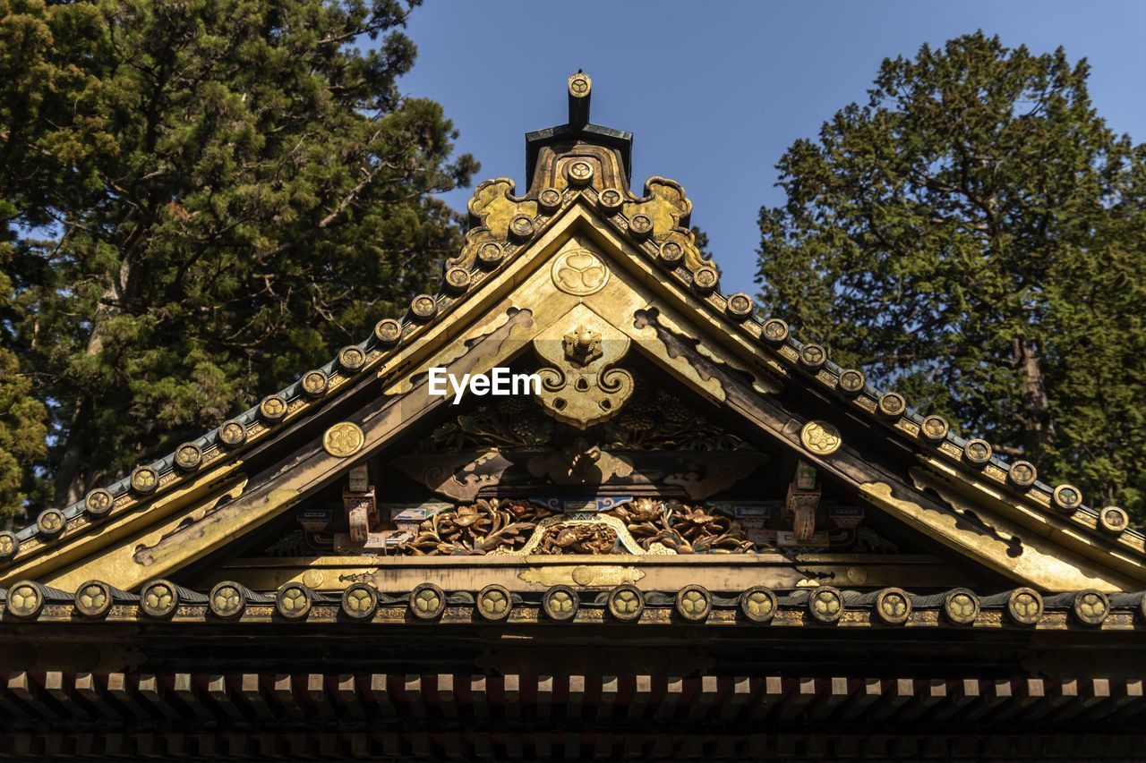 Low angle view of japanese ornate roof on temple against sky