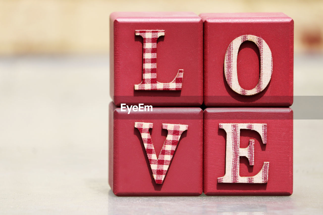 Close-up of red love text on table