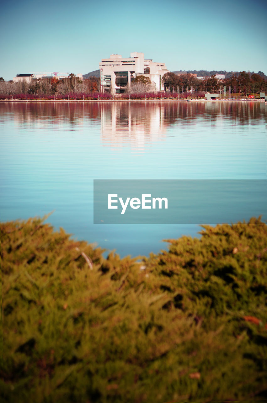 Calm blue sea with buildings in background