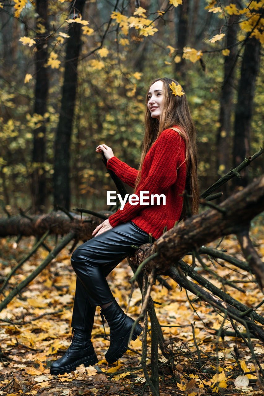 Autumn portrait of candid beautiful girl with fall leaves in hair. portrait of happy woman in fall