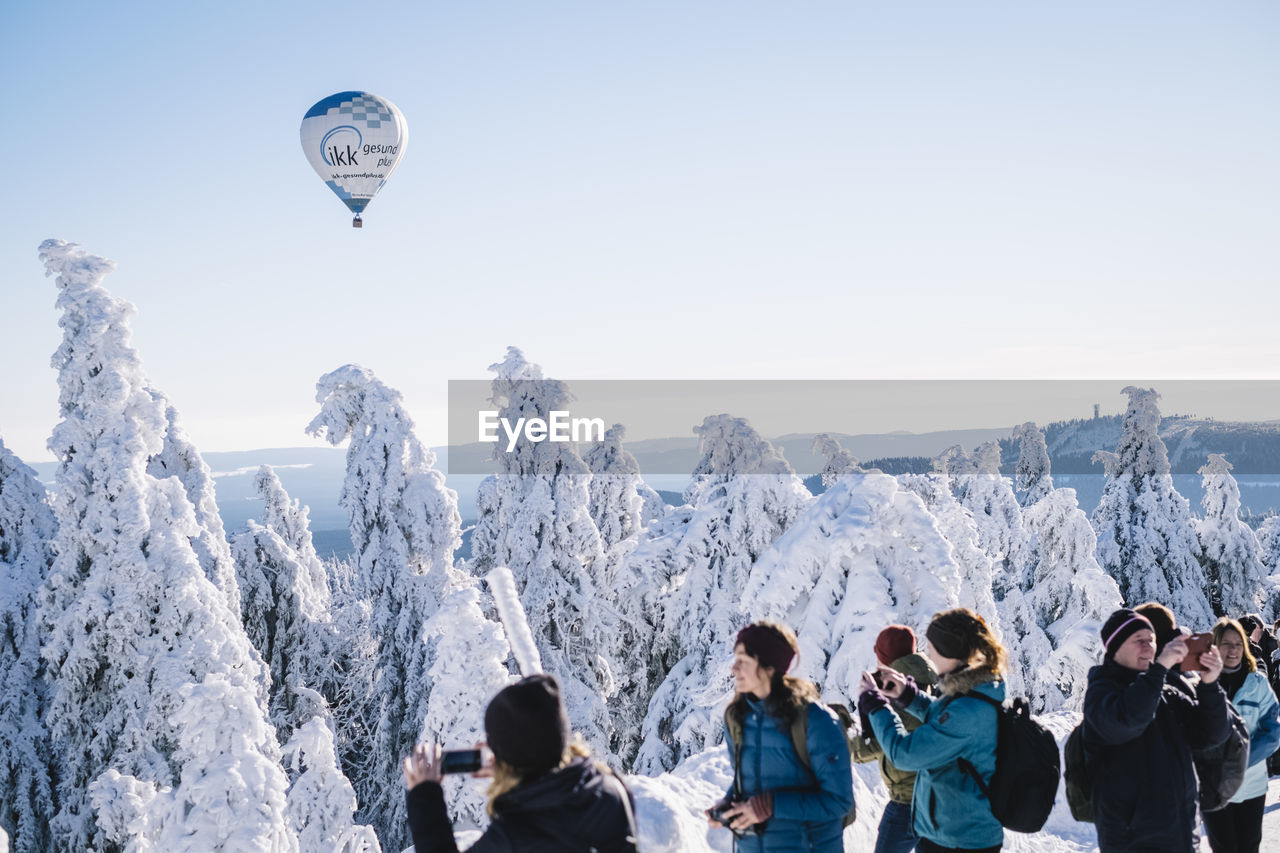 PEOPLE ON SNOWCAPPED MOUNTAINS AGAINST SKY