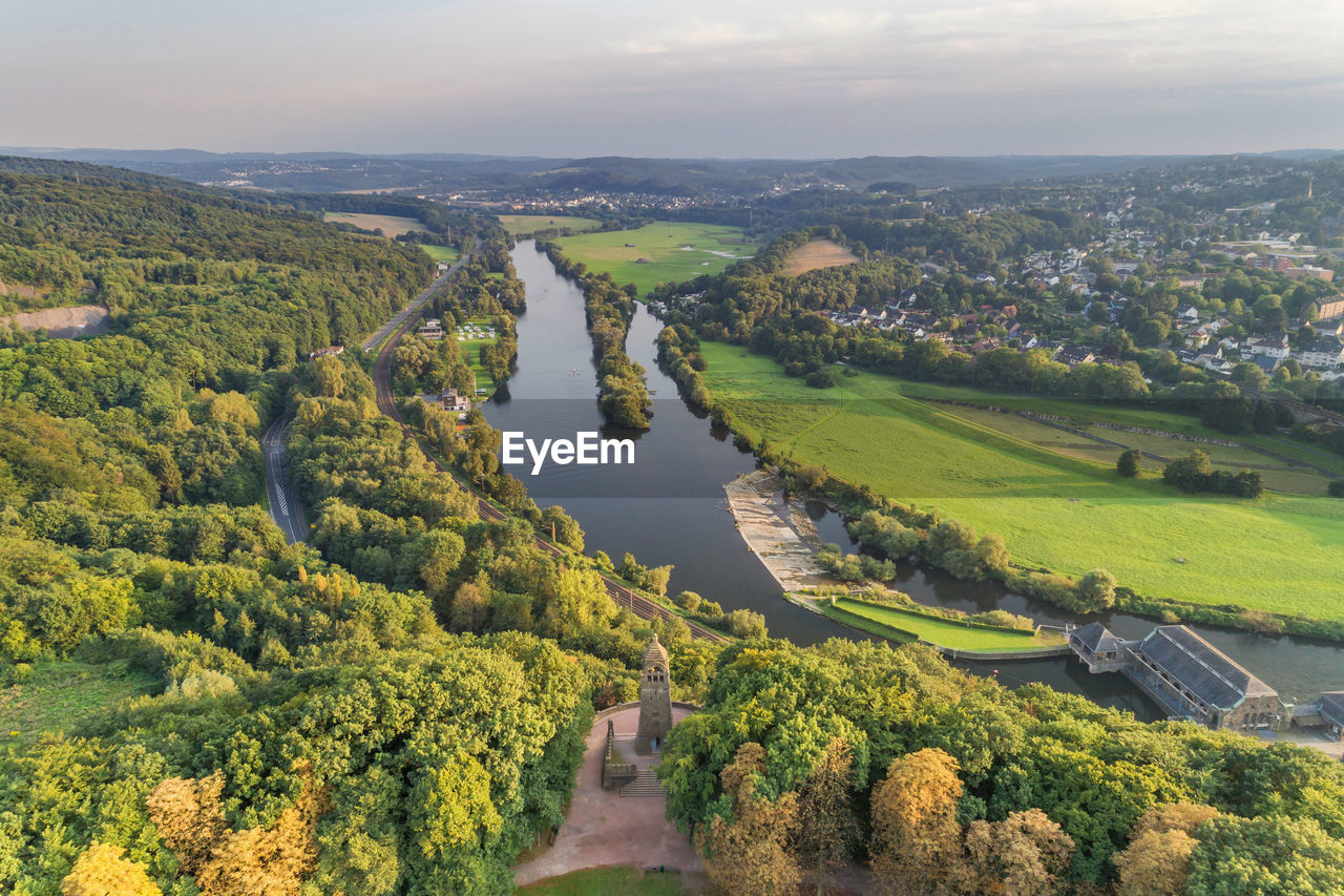 HIGH ANGLE VIEW OF GREEN LANDSCAPE AND CITY AGAINST SKY