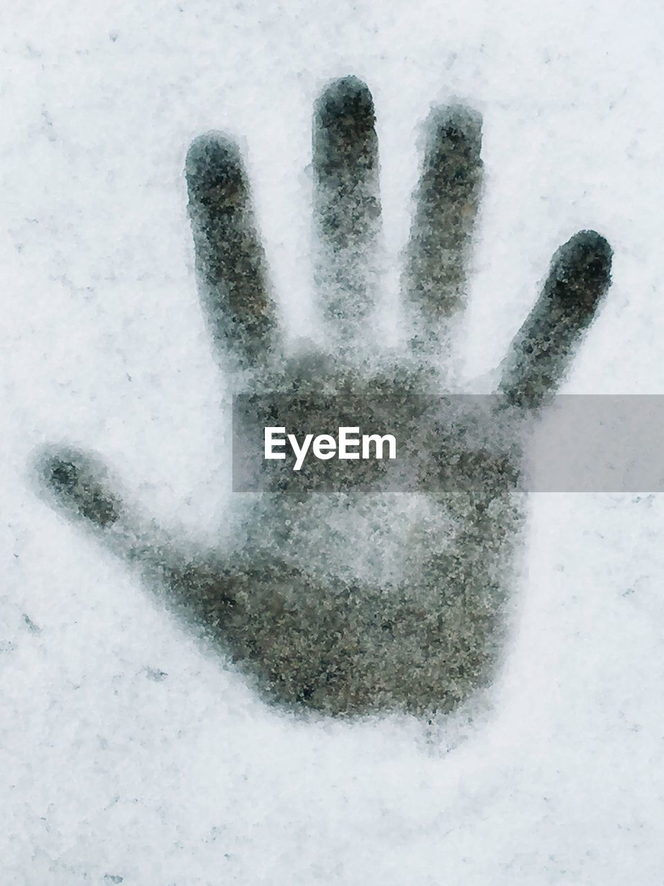 Close-up of handprint on snow covered field
