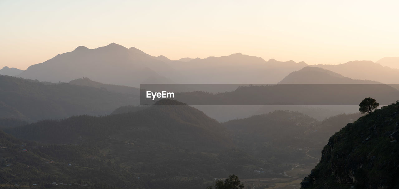 scenic view of mountains against orange sky during sunset