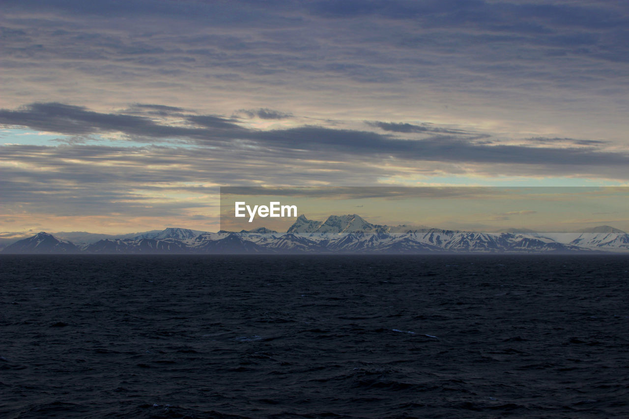 Scenic view of snowcapped mountains against sky during sunset