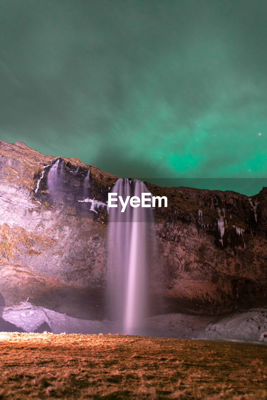 Northen light at seljalandsfoss waterfall, iceland.