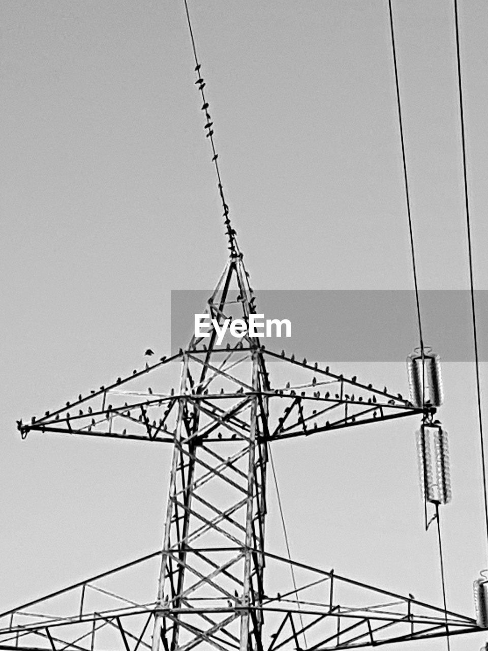 DIRECTLY BELOW SHOT OF ELECTRICITY PYLON AGAINST SKY