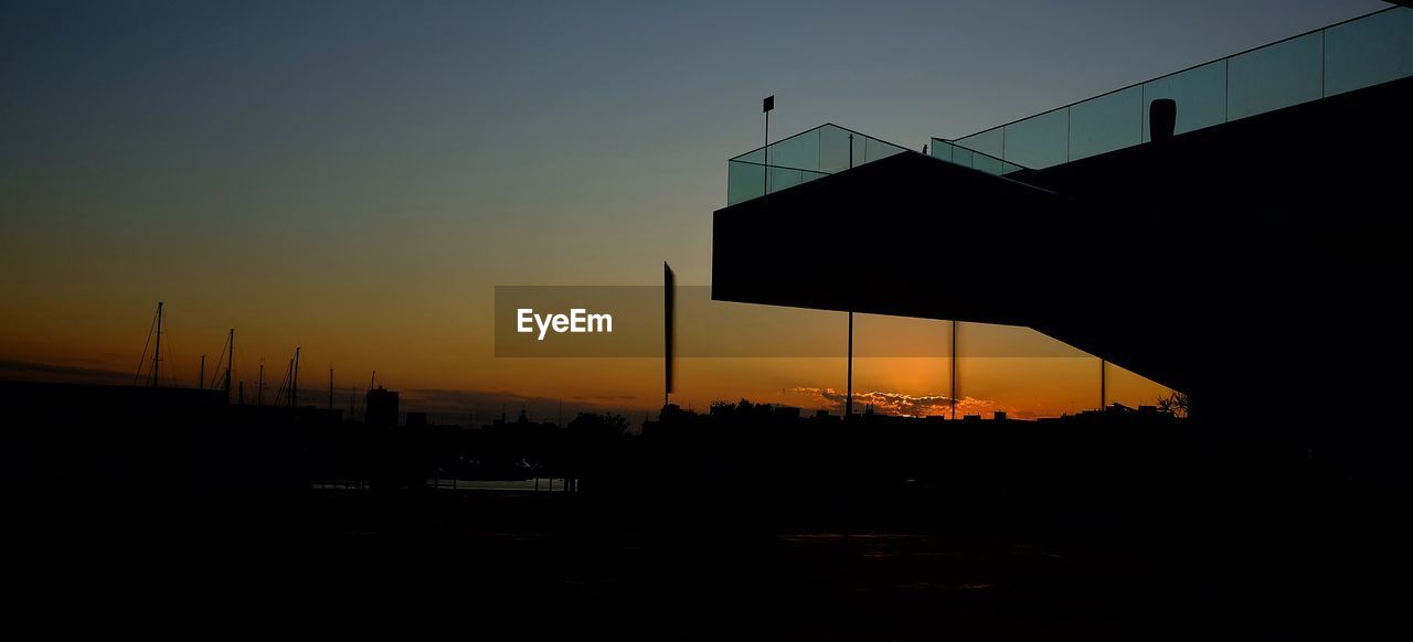 Silhouette bridge against clear sky during sunset