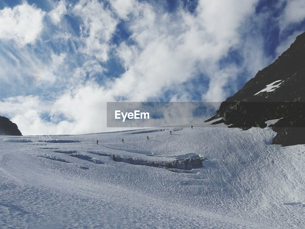 Scenic view of snow covered mountain against cloudy sky