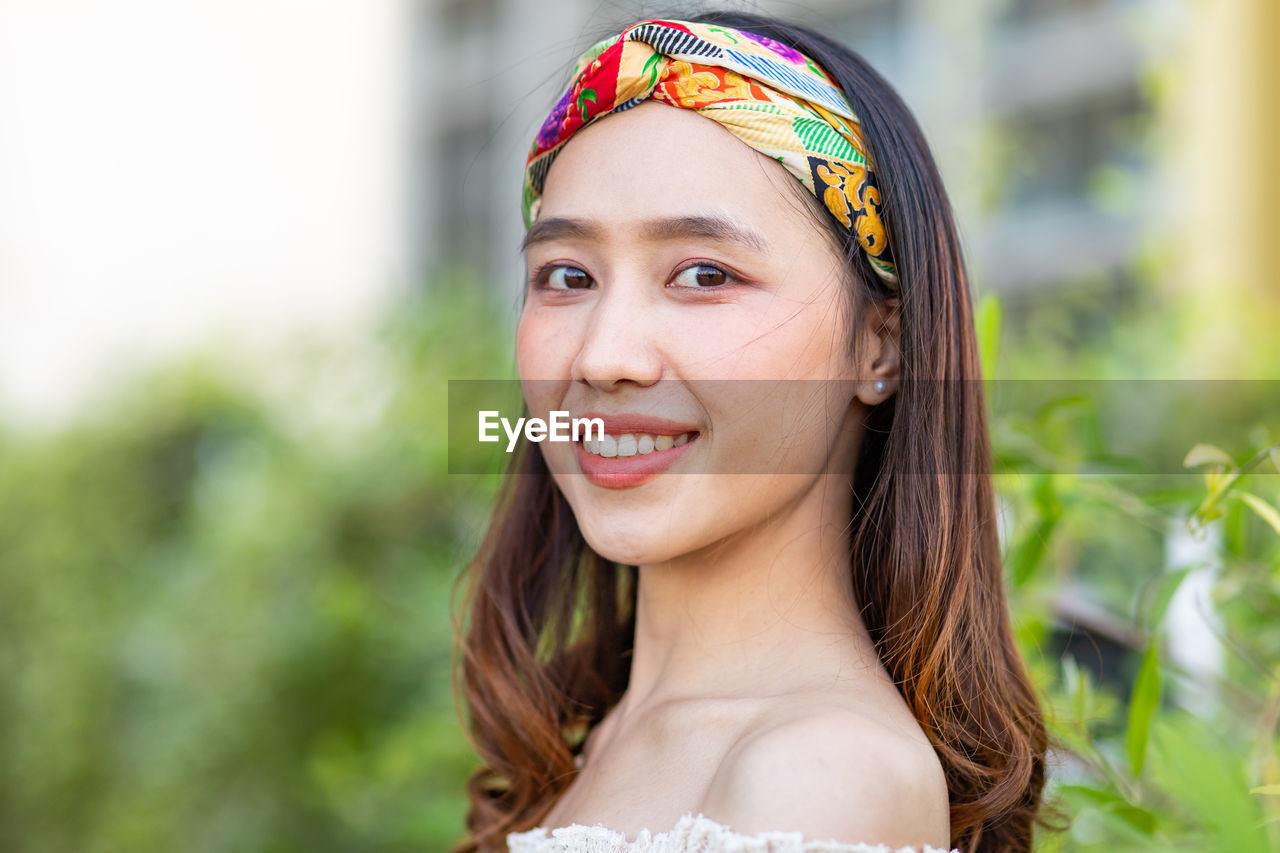 PORTRAIT OF YOUNG WOMAN SMILING OUTDOORS