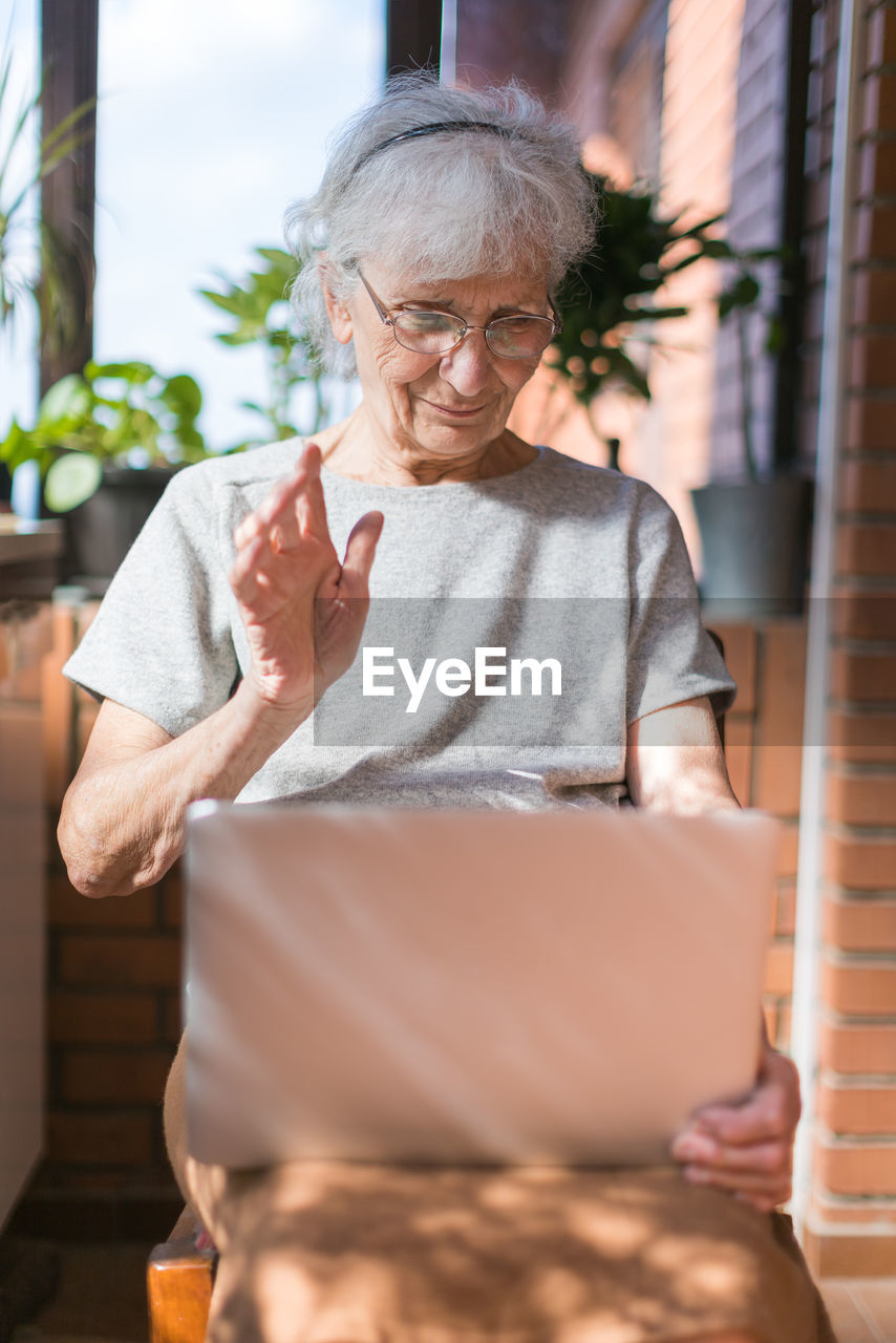 Portrait of smiling woman using laptop