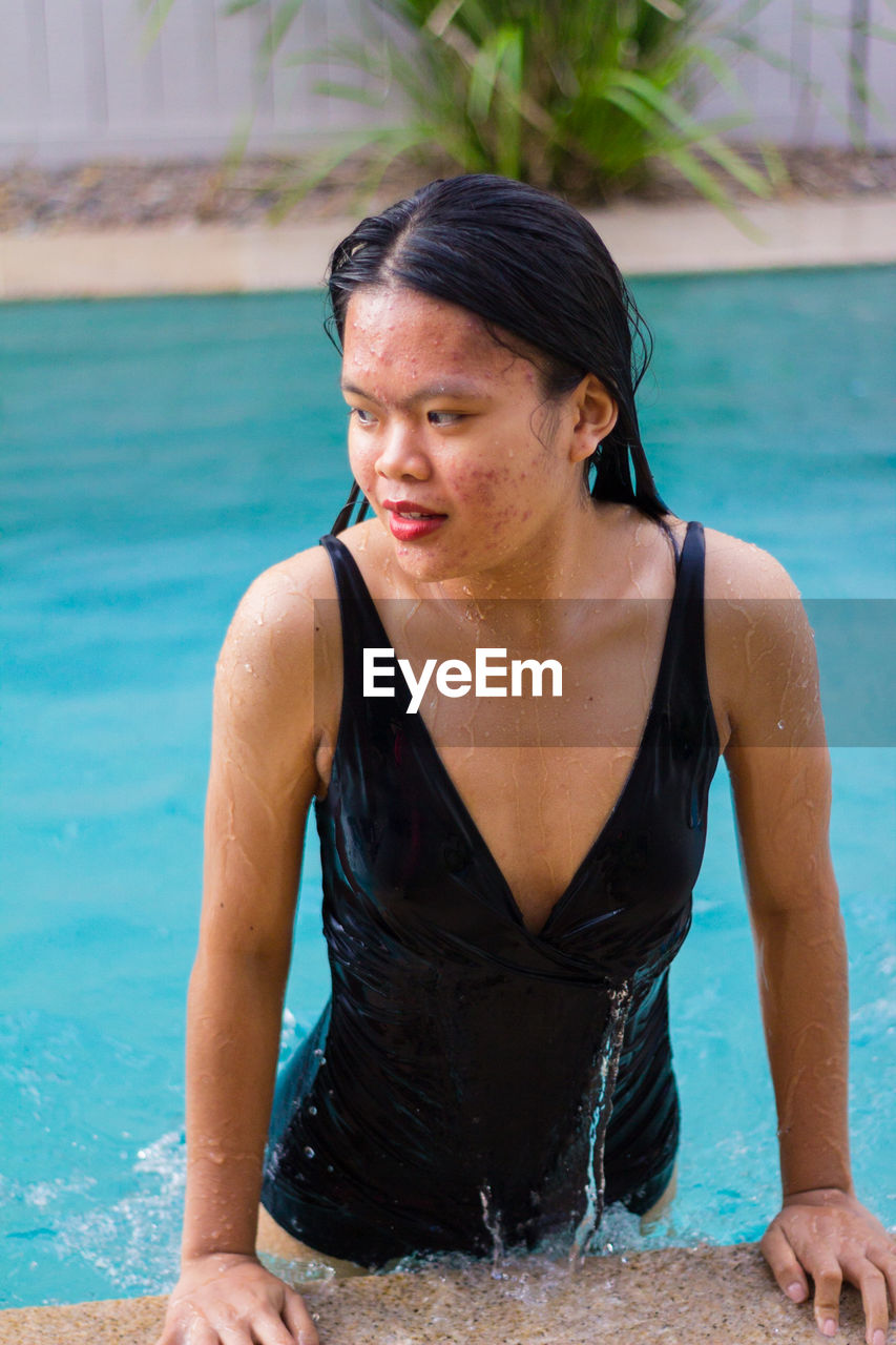 Close up view of sensuous asian woman standing in pool