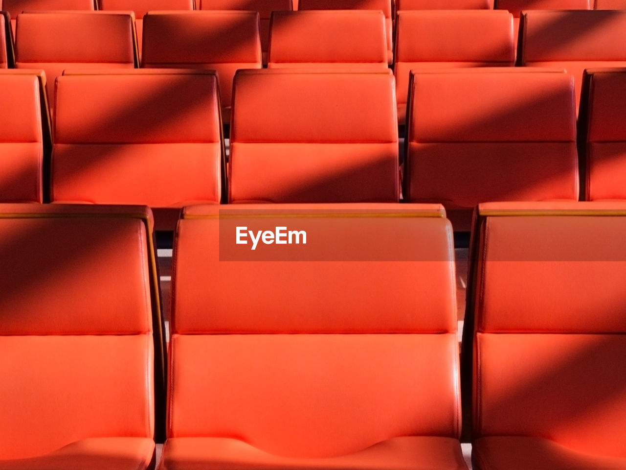 Full frame shot of empty red chairs in movie theater