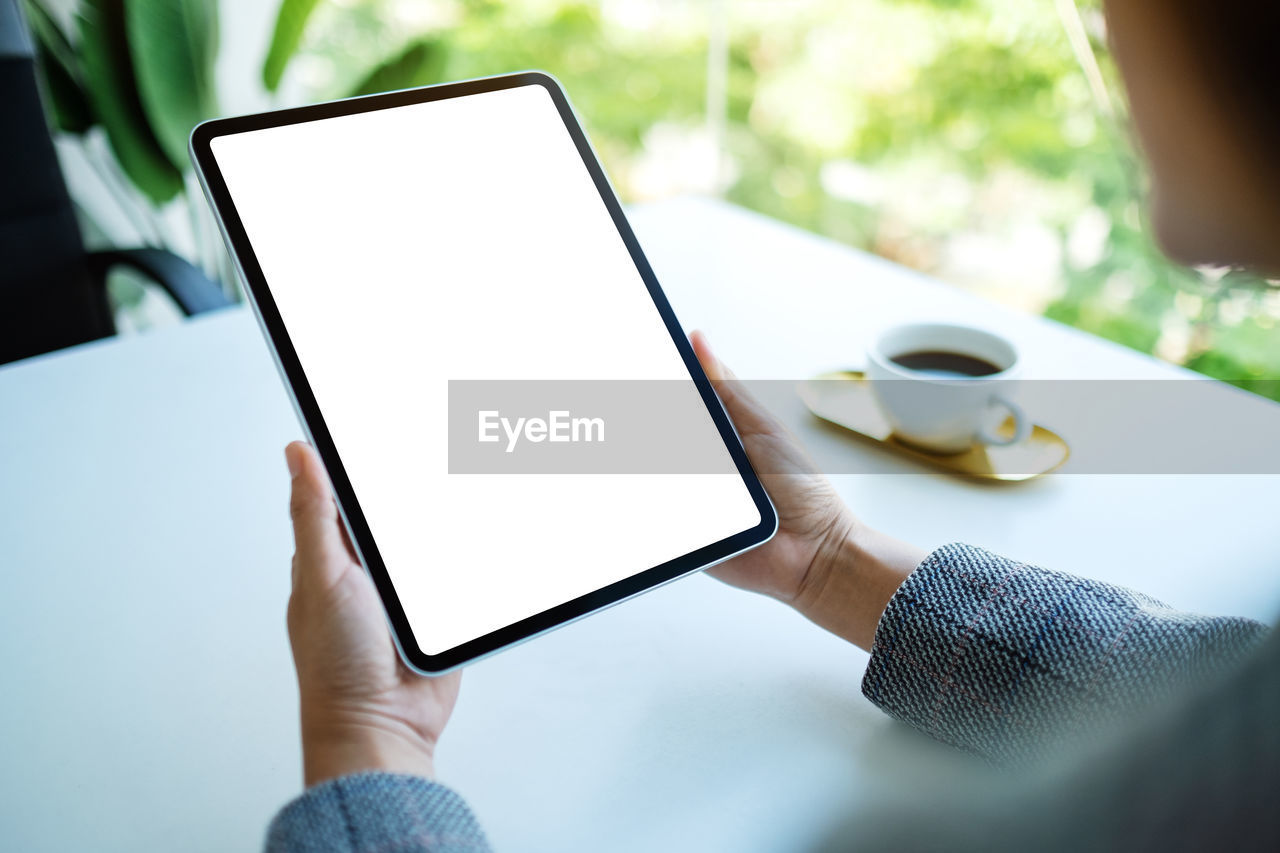 wireless technology, technology, communication, digital tablet, computer, adult, internet, table, cup, portability, computer network, tableware, coffee cup, hand, business, one person, mug, coffee, holding, food and drink, tablet computer, smartphone, portable information device, drink, using computer, indoors, writing, screen, copy space, relaxation, selective focus, women, laptop, touch screen, lifestyles, mobile phone, casual clothing, young adult, men, activity, day, leisure activity