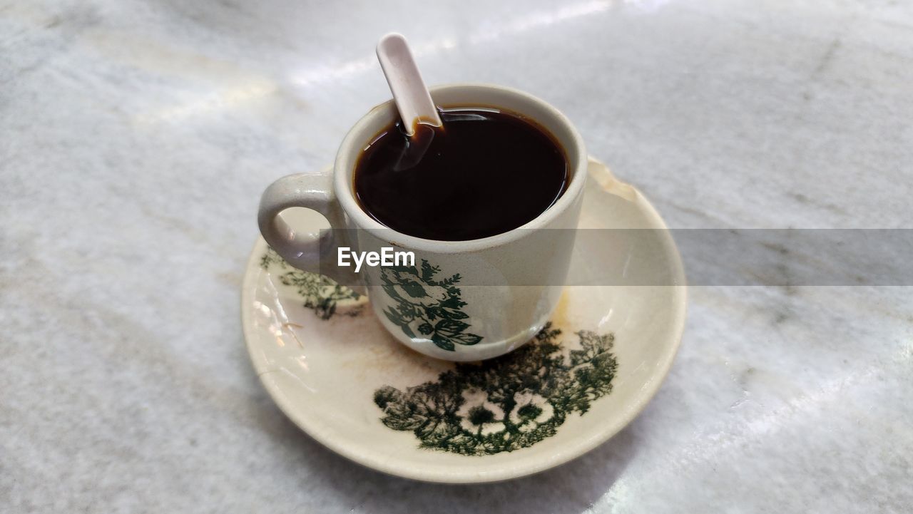food and drink, drink, cup, mug, refreshment, coffee, hot drink, crockery, coffee cup, tea, food, turkish coffee, saucer, spoon, high angle view, table, freshness, kitchen utensil, tea cup, eating utensil, tableware, indoors, no people, black coffee, caffè americano, close-up, still life, healthy eating, wellbeing