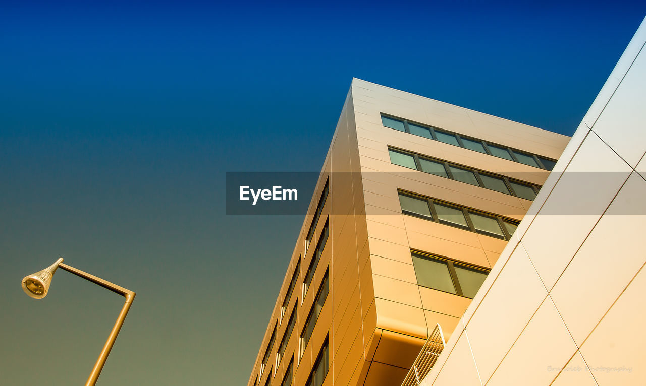 Low angle view of modern building against clear blue sky