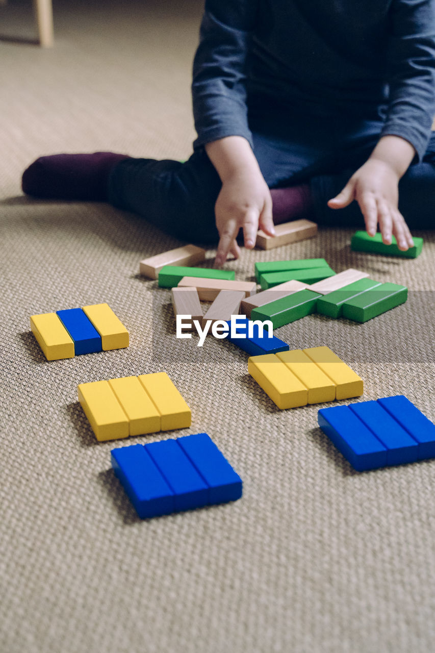 Low section of child playing with blocks in home