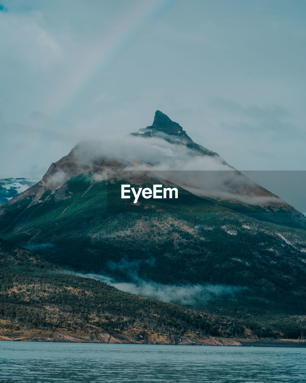 Scenic view of sea and snowcapped mountains against sky