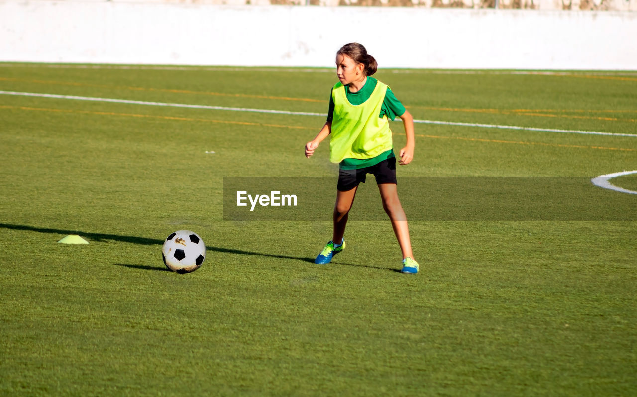 Girl playing soccer on field