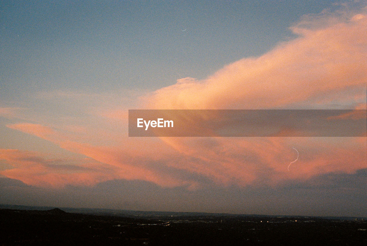 Scenic view of dramatic sky overcity during sunset