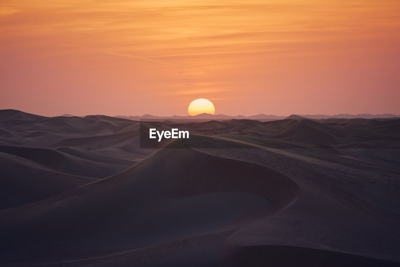 Sand dunes in desert landscape at beautiful sunset. abu dhabi, united arab emirates