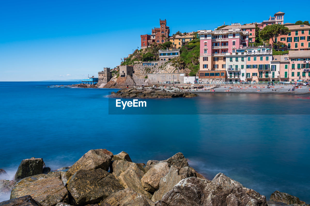 PANORAMIC VIEW OF SEA AND BUILDINGS AGAINST BLUE SKY