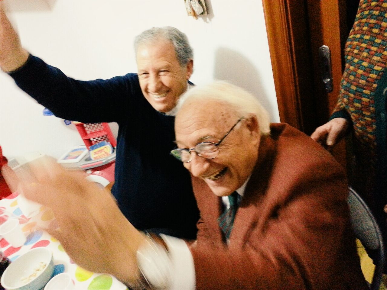 Cheerful mature and senior men at dining table