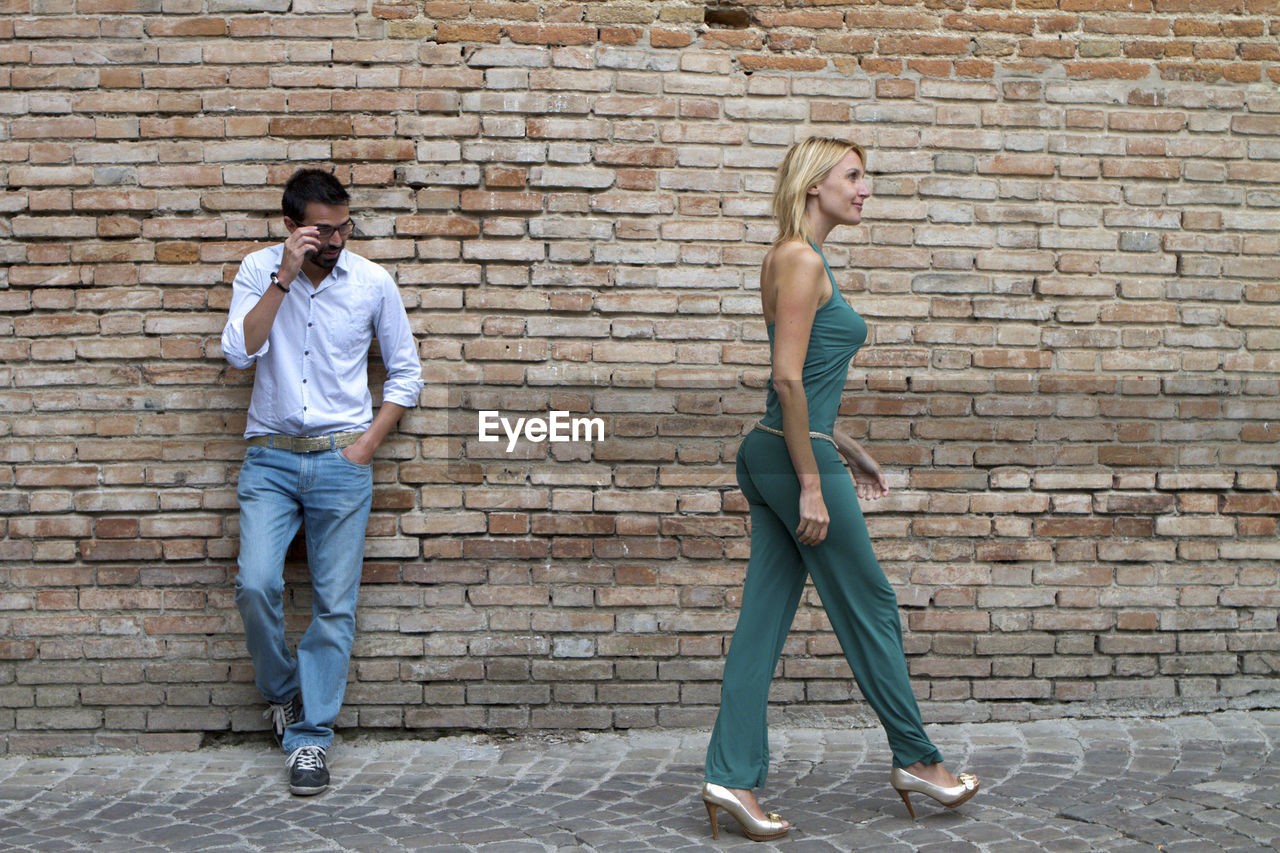 Man standing in a street and looking at a woman