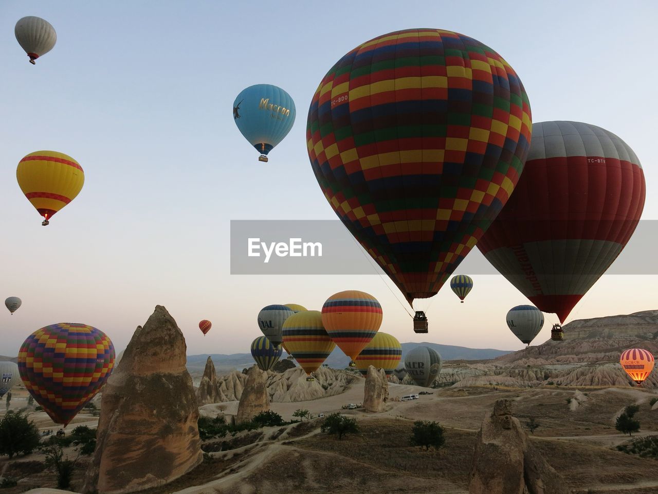 Hot air balloons flying over cappadocia against sky