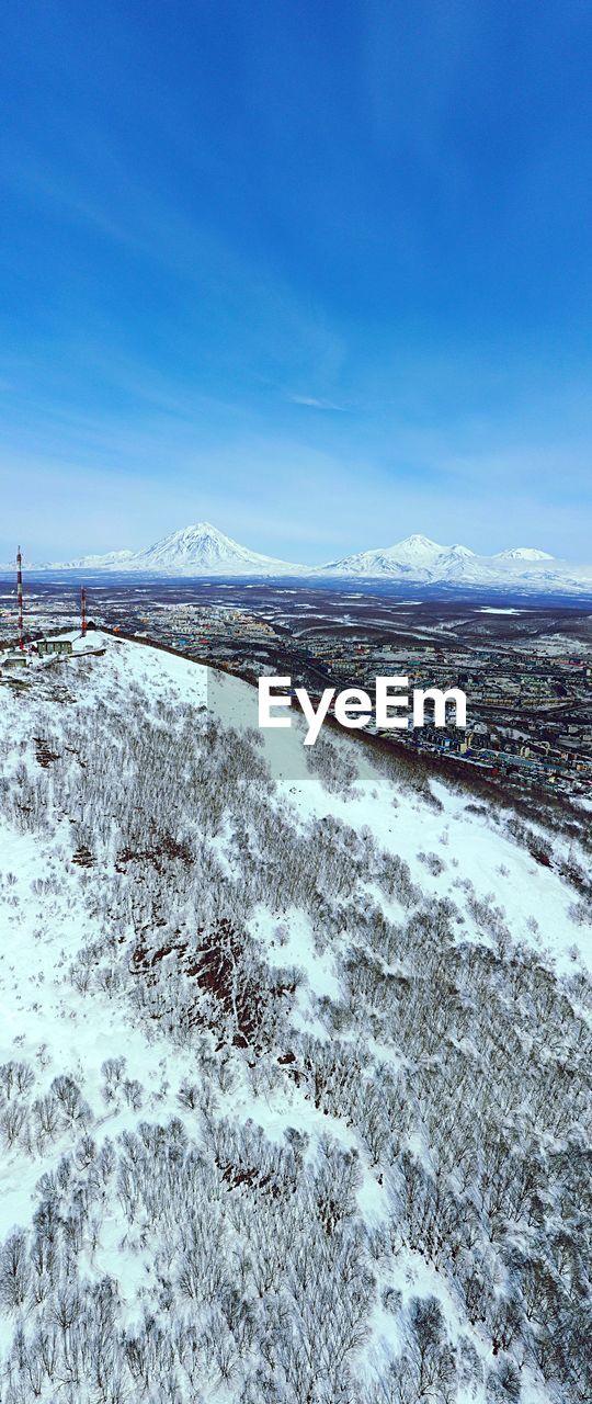 VIEW OF SNOW COVERED LAND AGAINST BLUE SKY