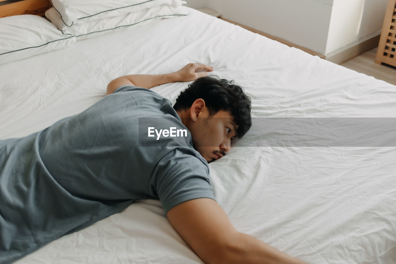 High angle view of man sleeping on bed