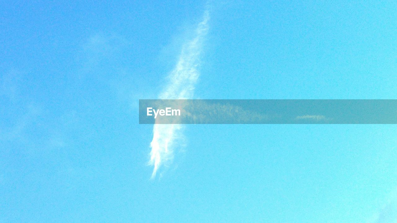 LOW ANGLE VIEW OF VAPOR TRAILS IN BLUE SKY