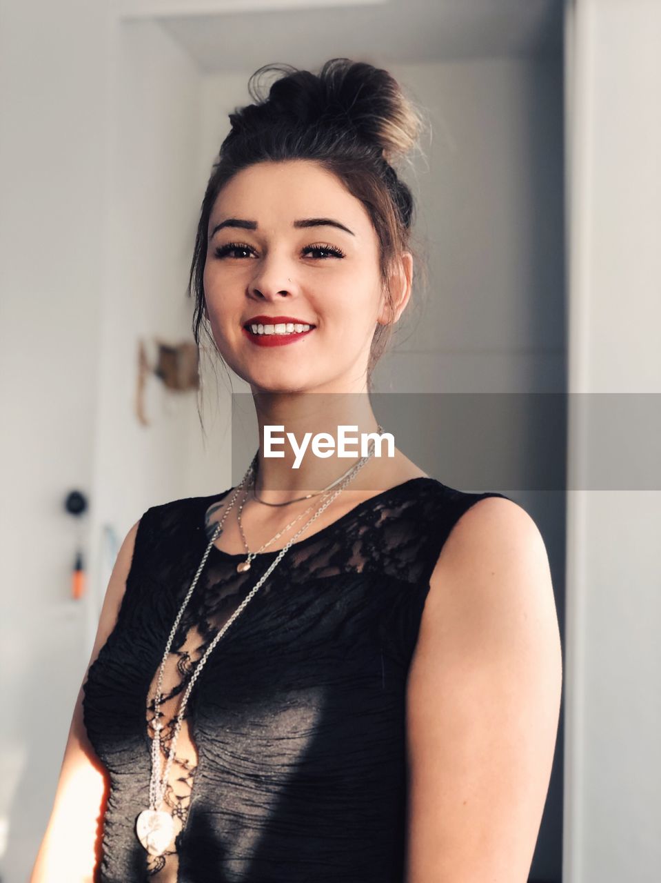 Portrait of smiling young woman standing at home