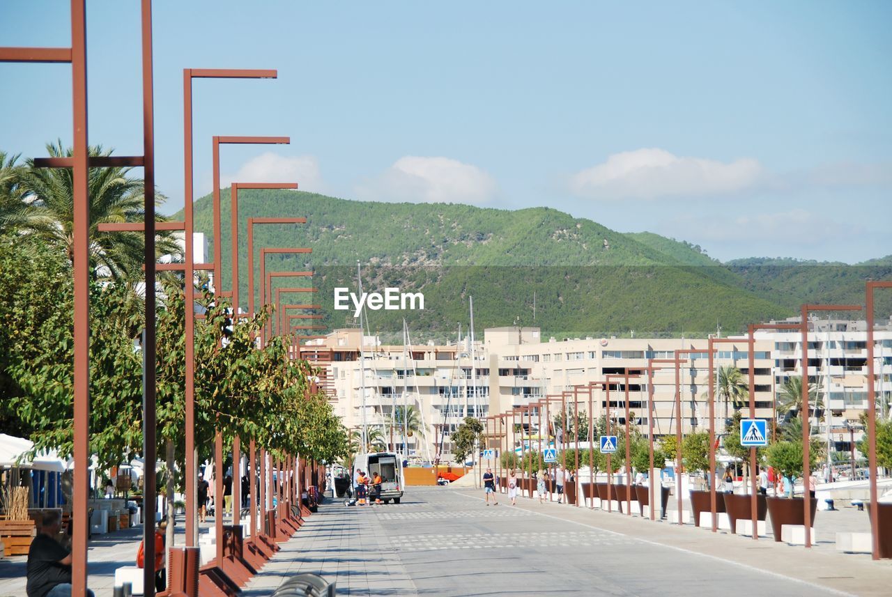 Road by buildings in city against sky