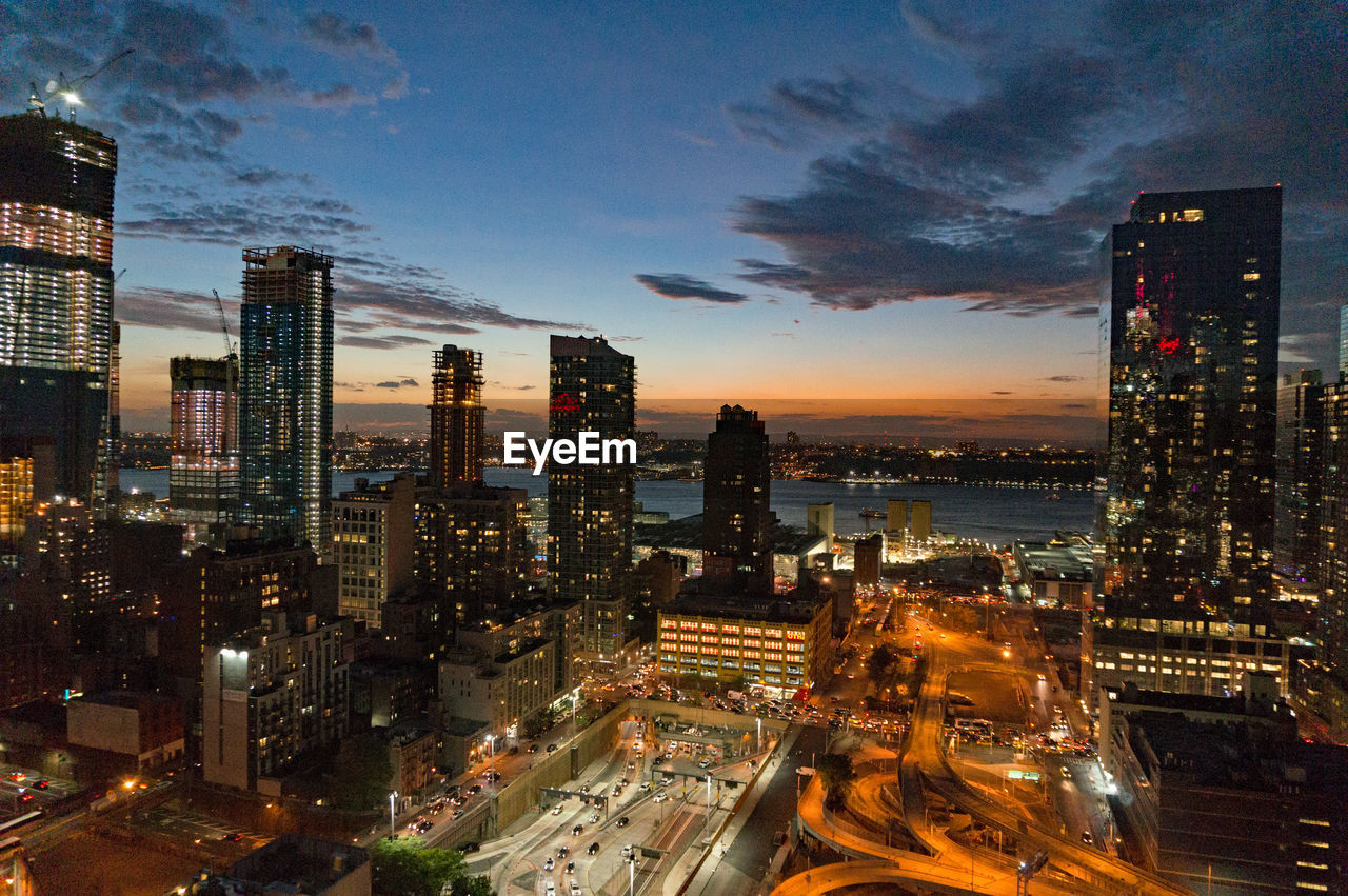 AERIAL VIEW OF ILLUMINATED CITY BUILDINGS AGAINST SKY