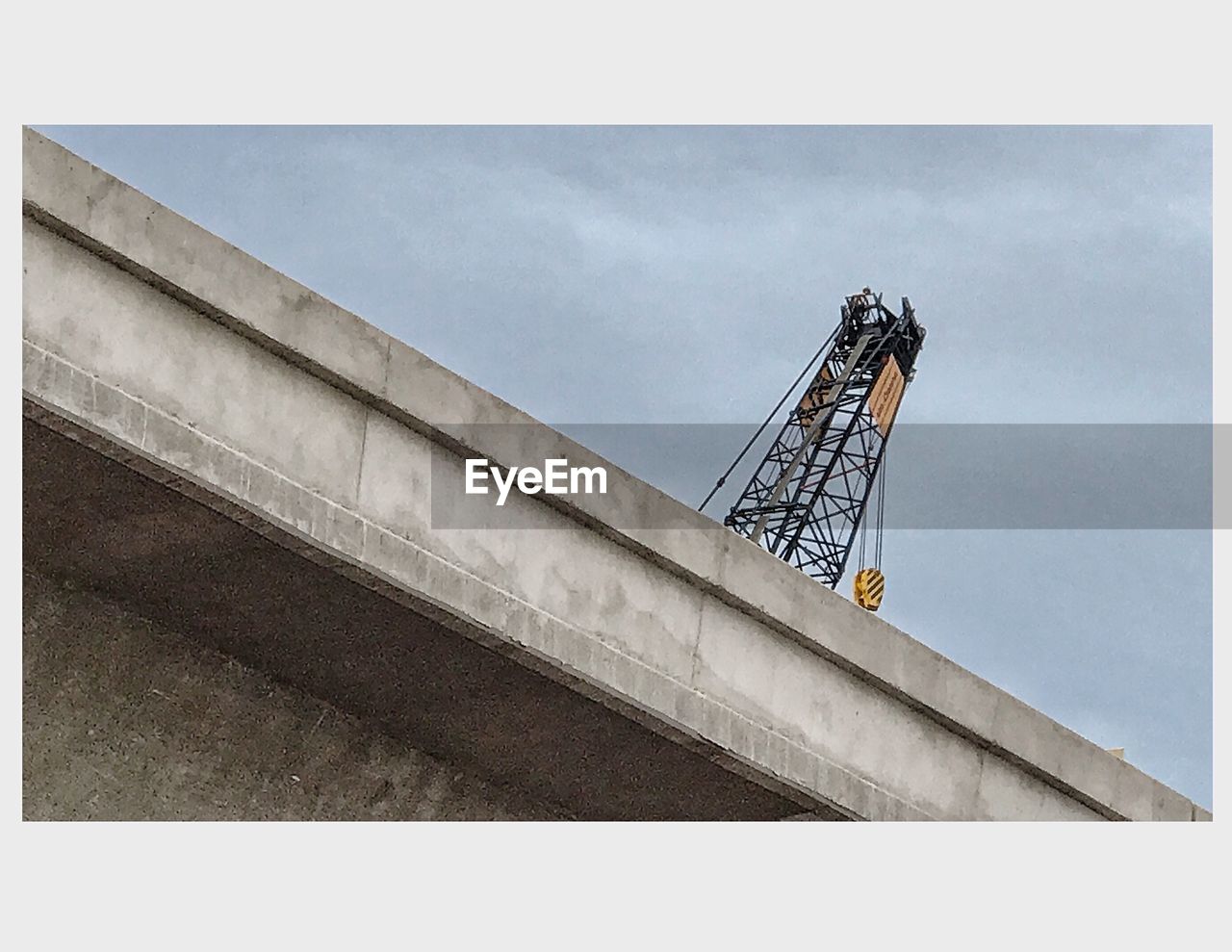 LOW ANGLE VIEW OF CONSTRUCTION CRANE AGAINST SKY