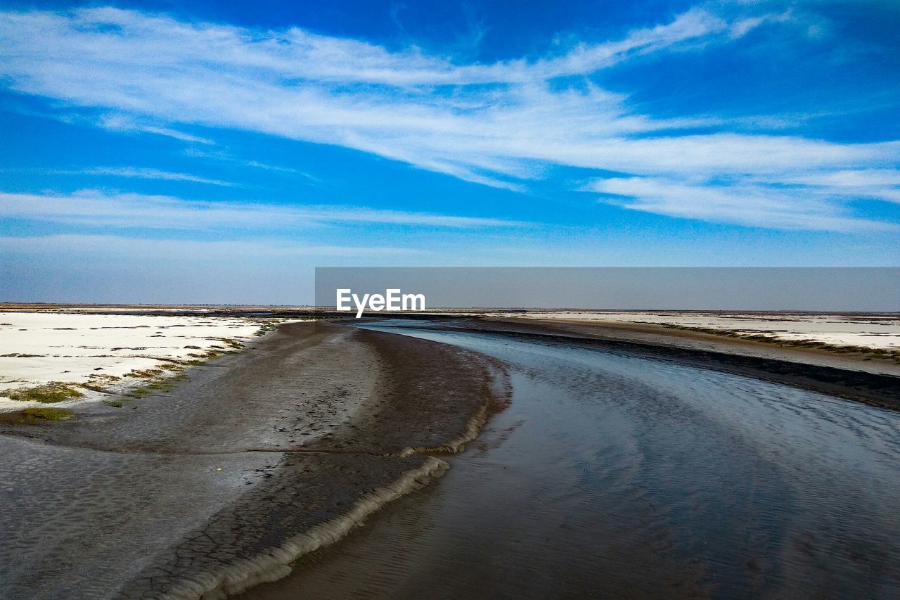 Scenic view of beach against blue sky