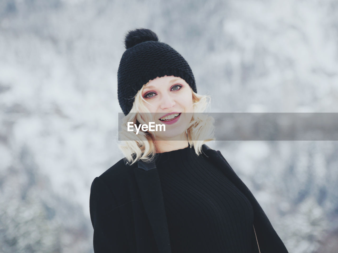 Portrait of mid adult woman standing on snow covered mountain