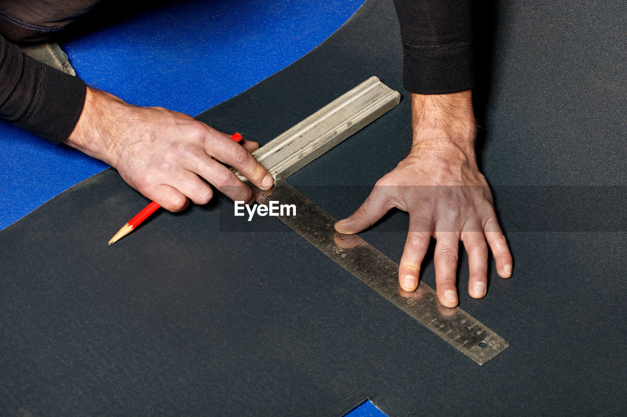 HIGH ANGLE VIEW OF MAN WORKING ON TABLE