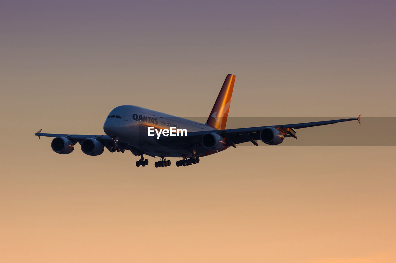 LOW ANGLE VIEW OF AIRPLANE AGAINST CLEAR SKY DURING SUNSET