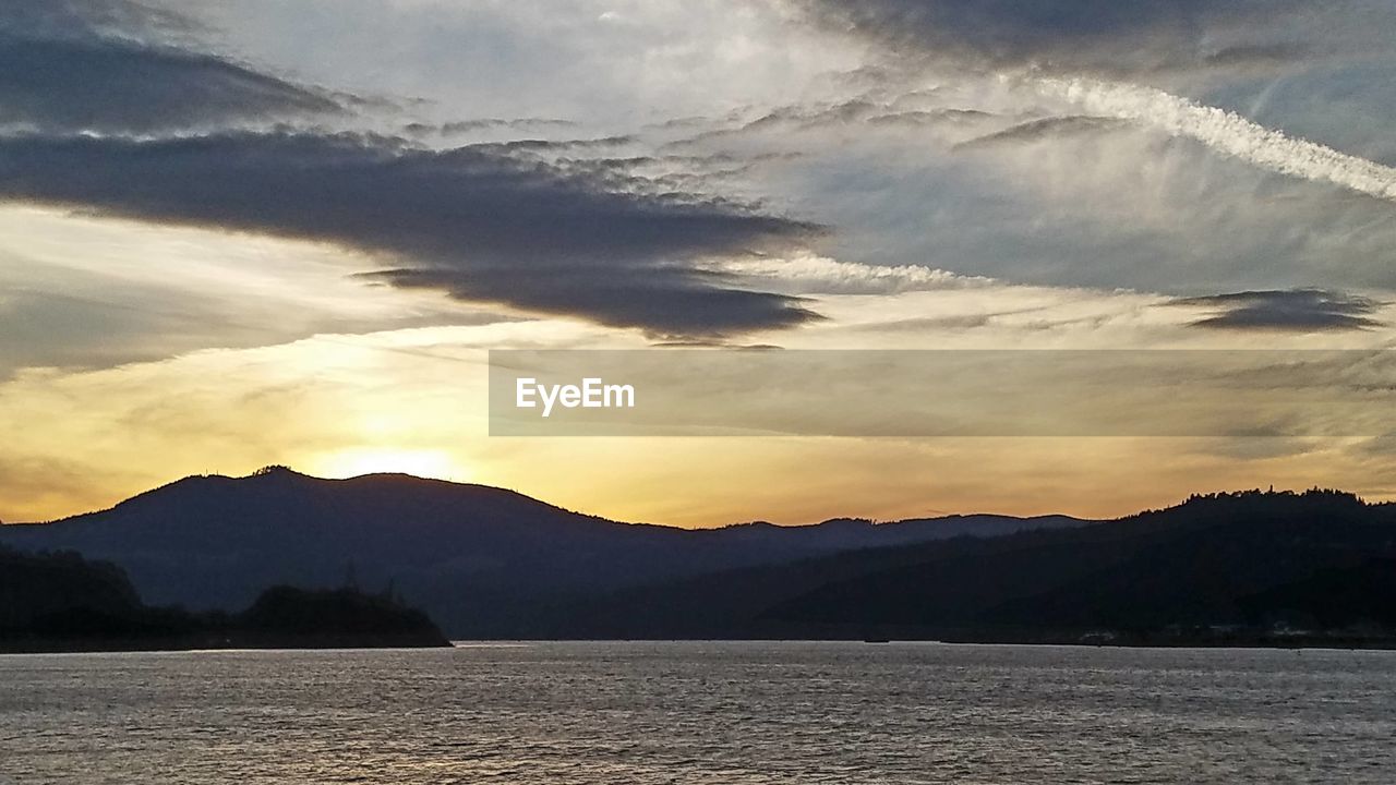 Scenic view of lake and mountains against sky