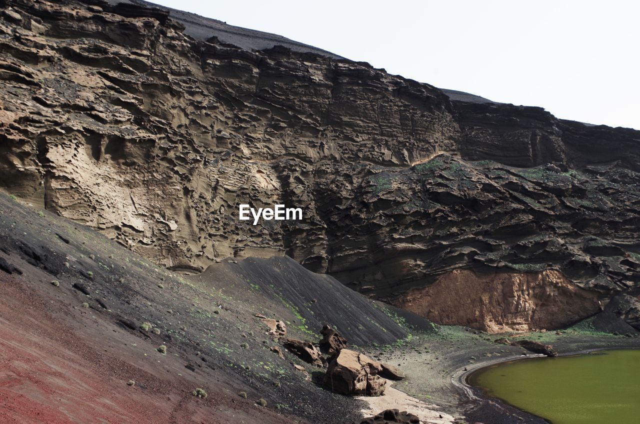 Green lake by rocky cliff at el golfo