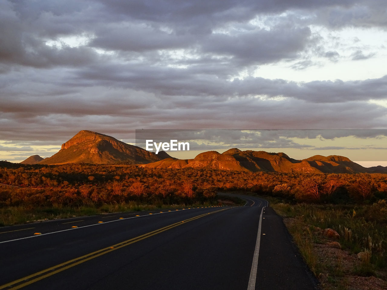 Empty road along countryside landscape