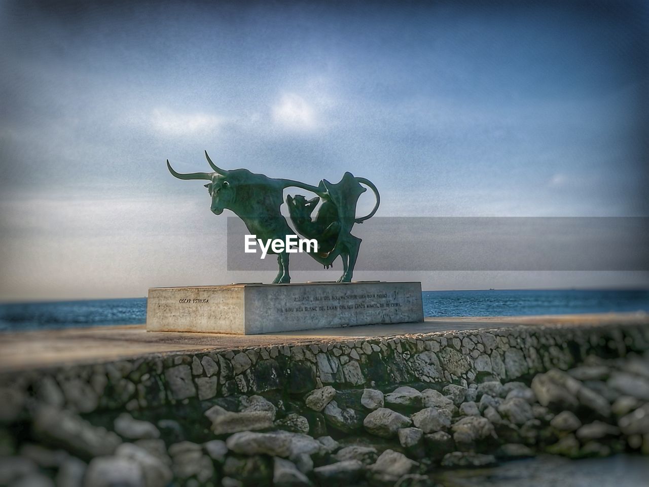 STATUE ON SEA BY SCULPTURE AGAINST SKY