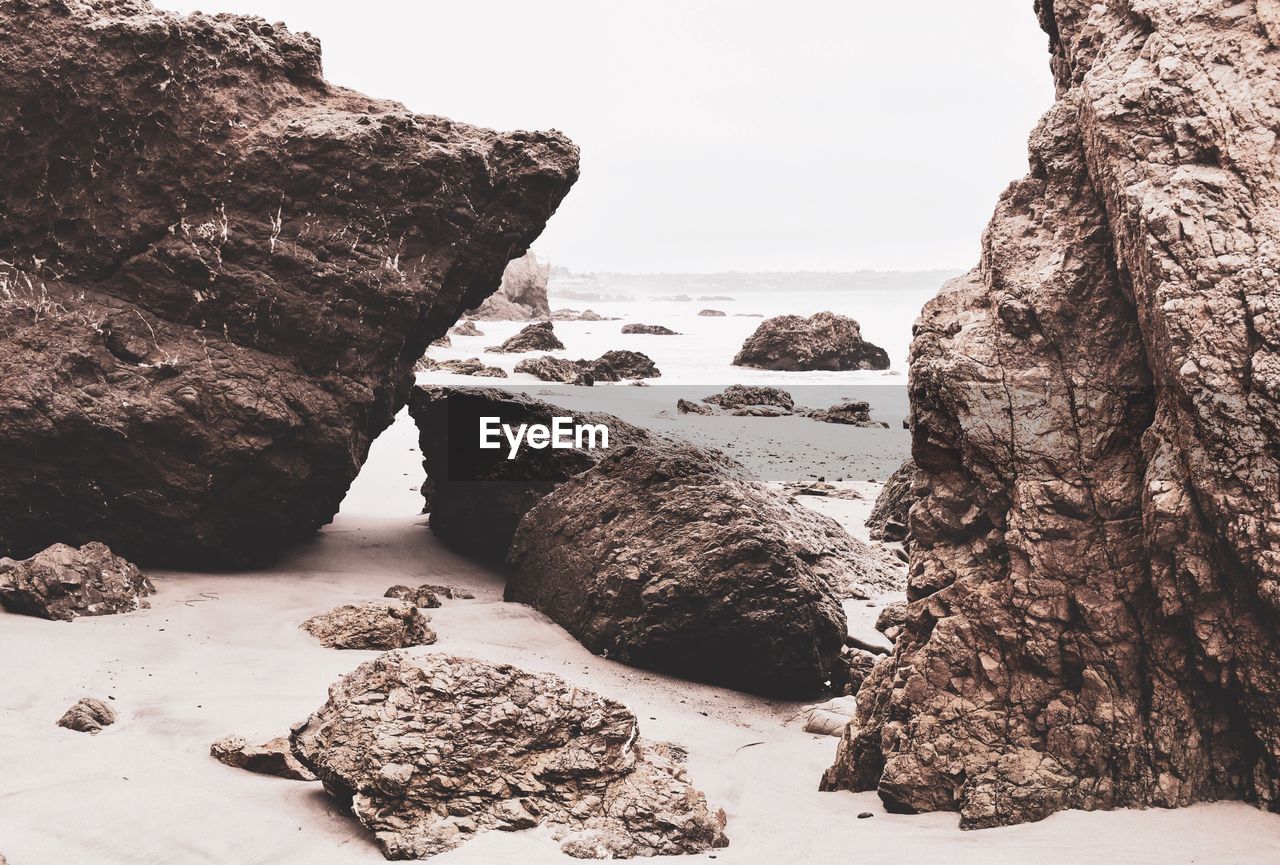 Rocks on beach against clear sky