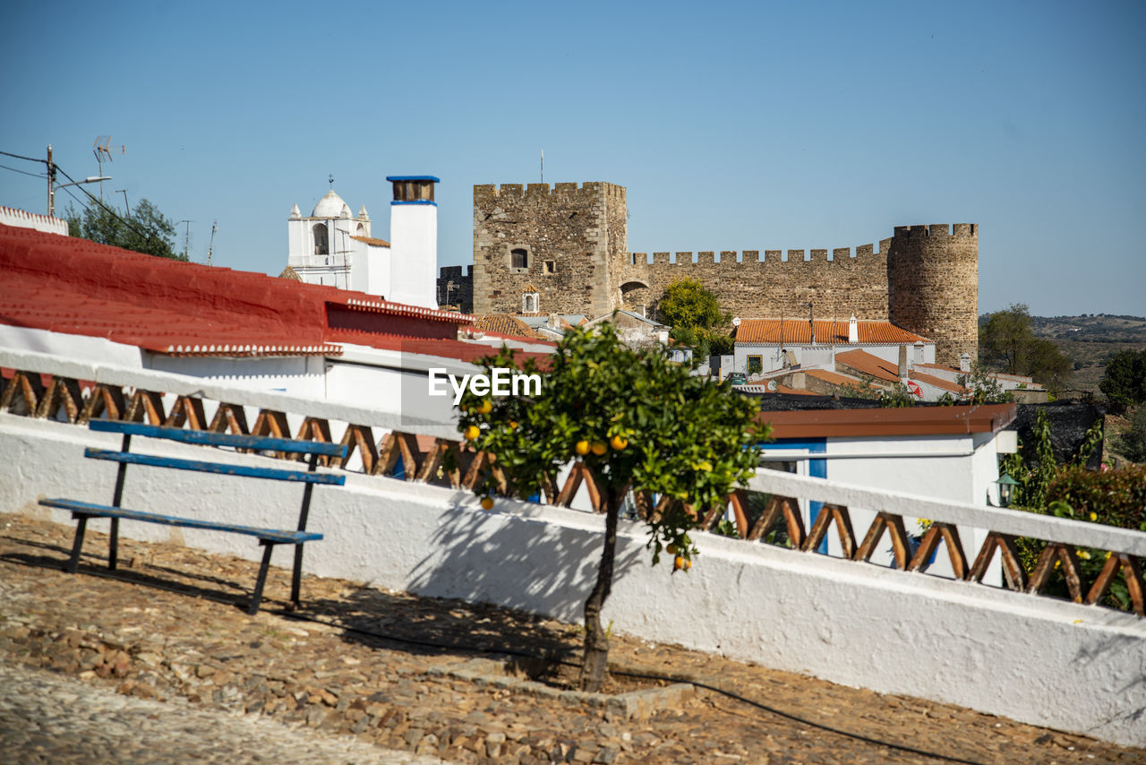 architecture, built structure, building exterior, urban area, city, building, sky, nature, vacation, clear sky, town, plant, travel destinations, tree, day, no people, history, sunny, outdoors, residential district, travel, the past, blue, house, sunlight, wall