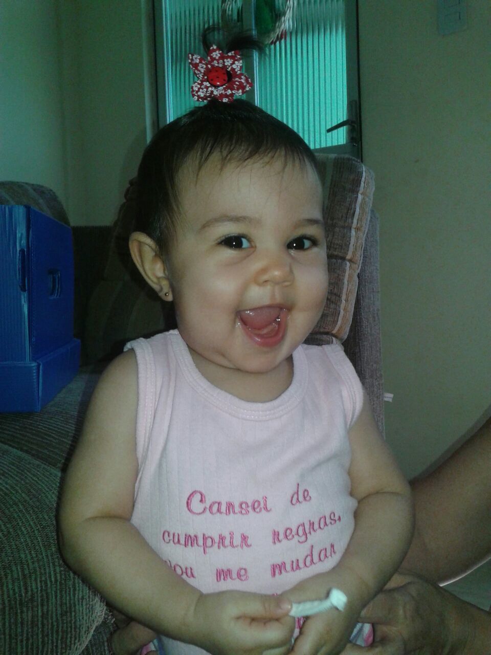 PORTRAIT OF CUTE SMILING GIRL SITTING ON SOFA