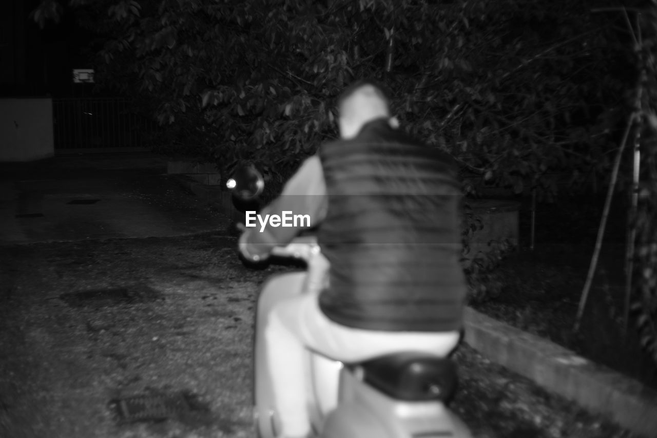 REAR VIEW OF MAN HOLDING HANDS IN CITY
